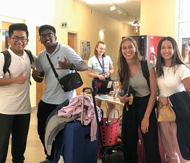 Waiting for the airport taxi Stundets with luggage in the campus hall