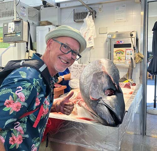 Man pointing at a huge fish on a fish market