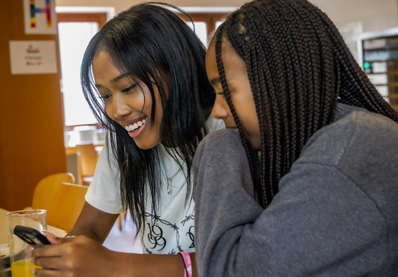 Two teenage student girls looking at a smartphone