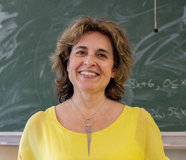 Smiling female teacher in front of a blackboard